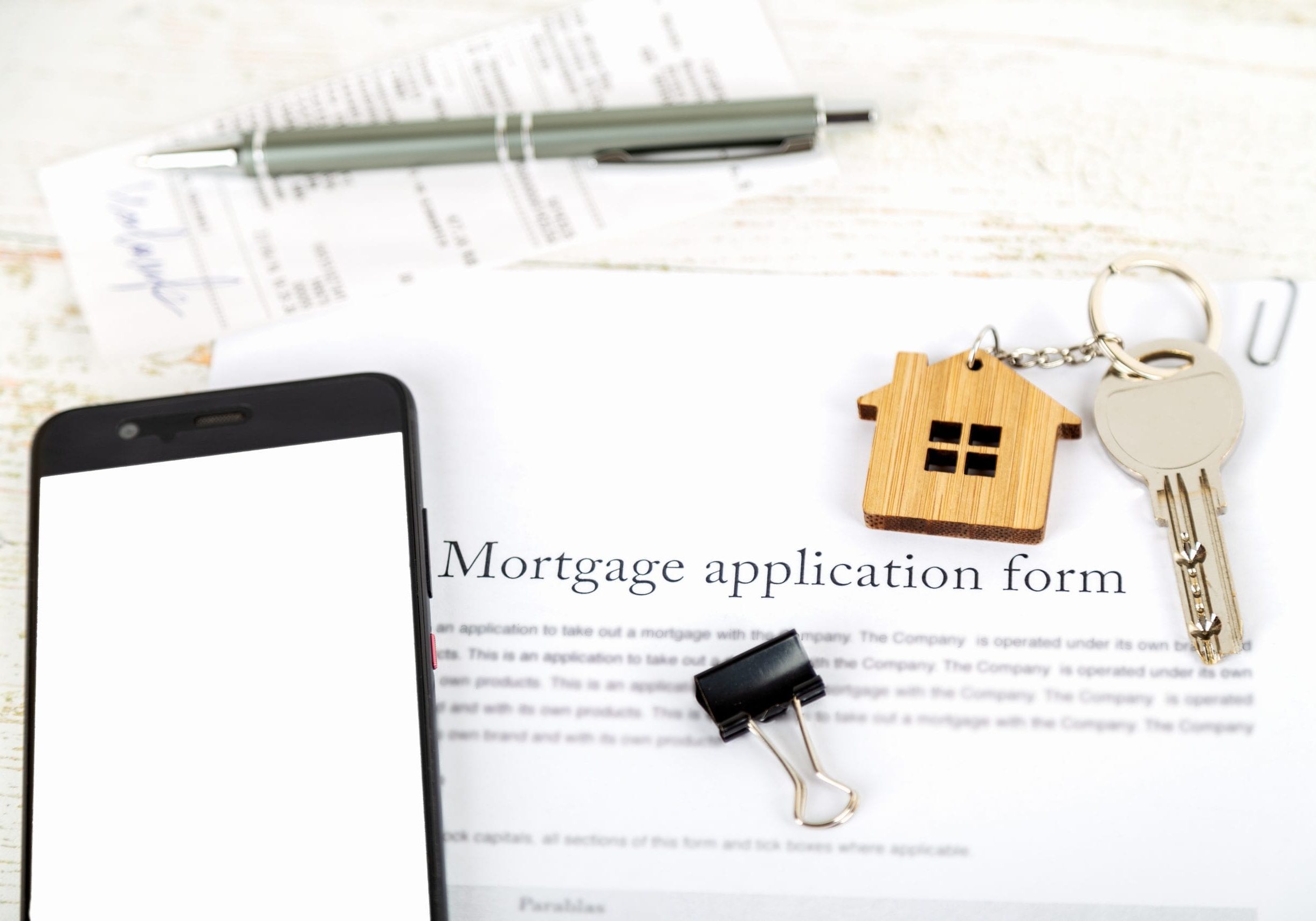 Mockup with smartphone screen and approved mortgage loan agreement application with house shaped keyring